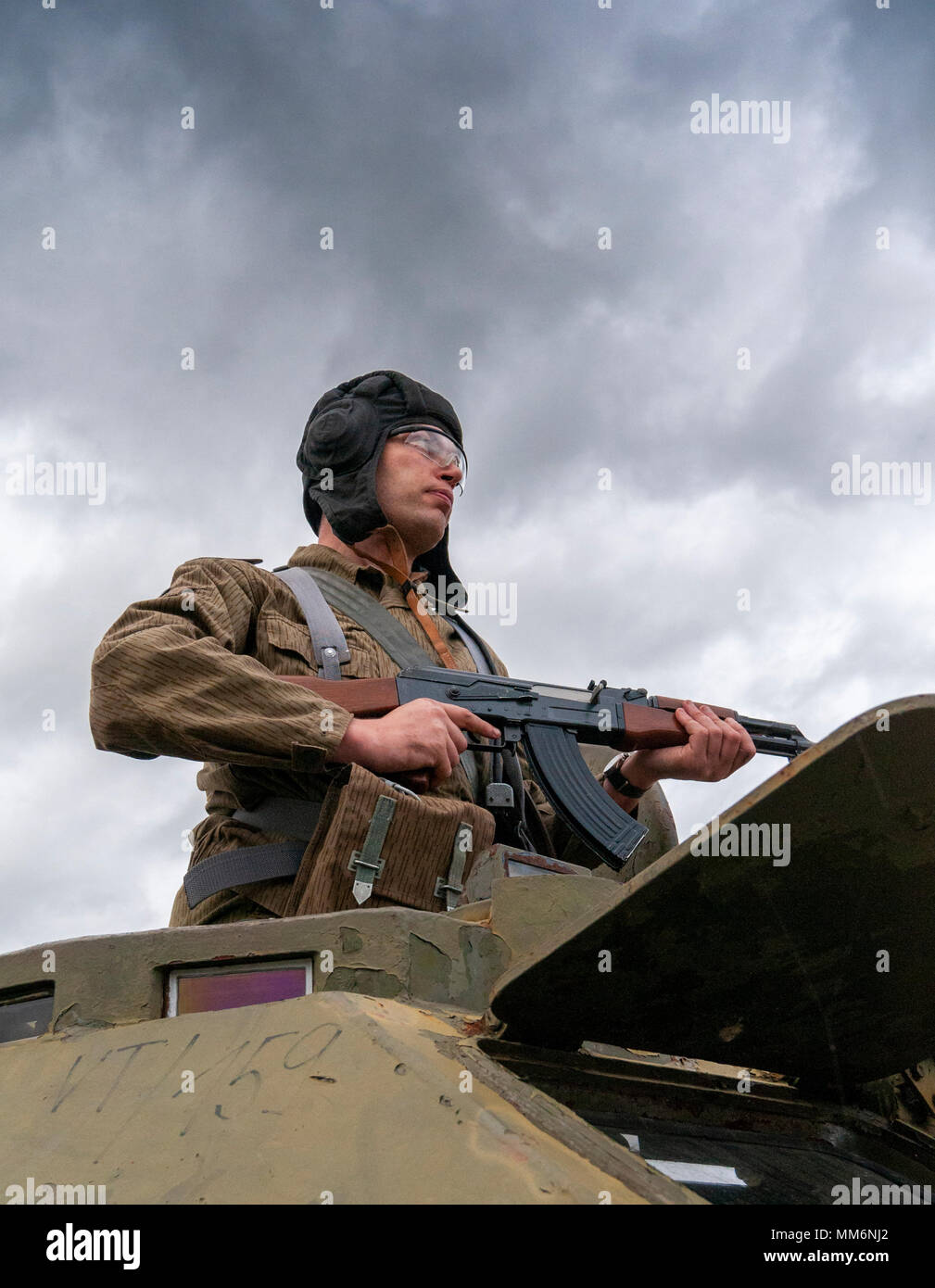 An airsoft player wearing East German, Junior Non-Commissioned Officers  uniform with an AK-47 stood by a BDRM soviet armoured vehicle Stock Photo -  Alamy