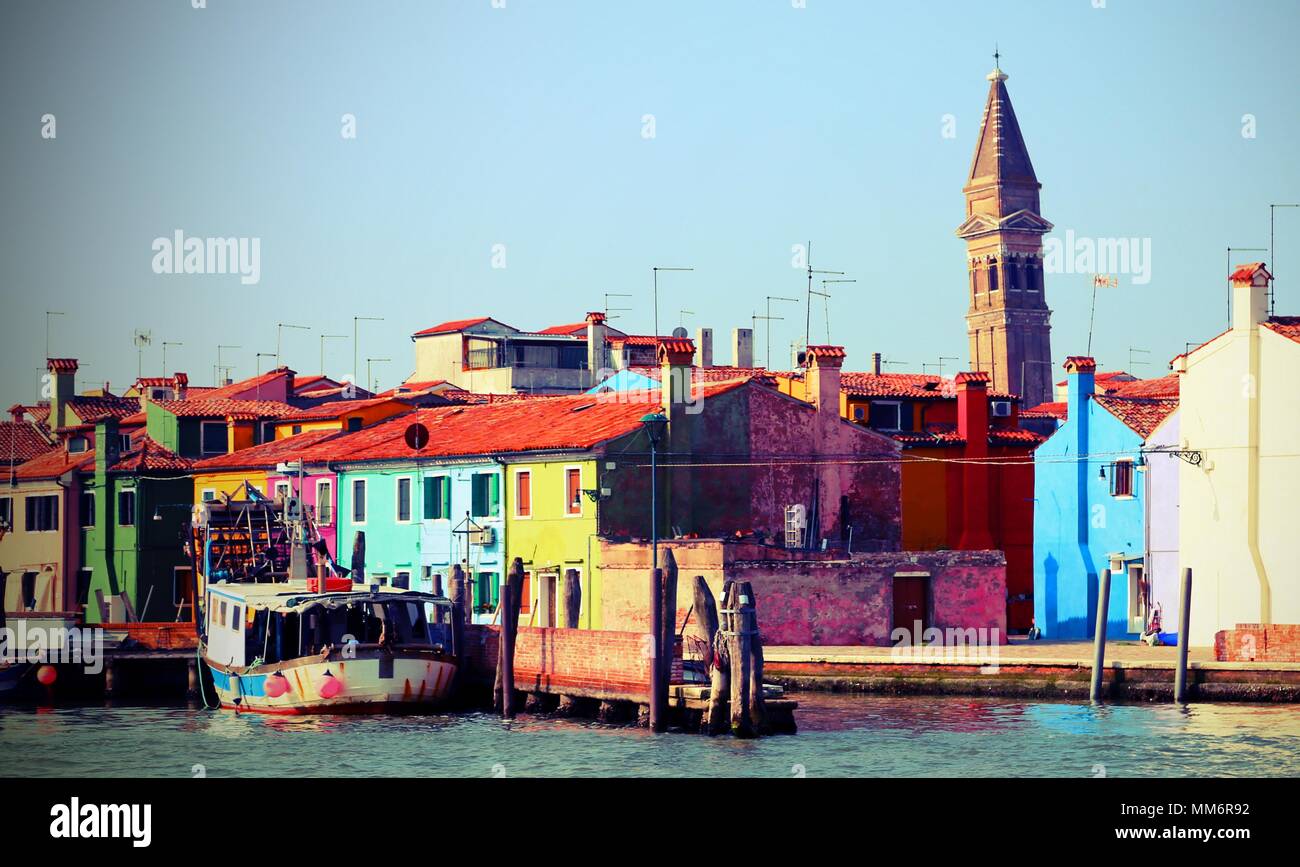 houses in Burano island near Venice in Italy and the bell tower with vintage effect Stock Photo