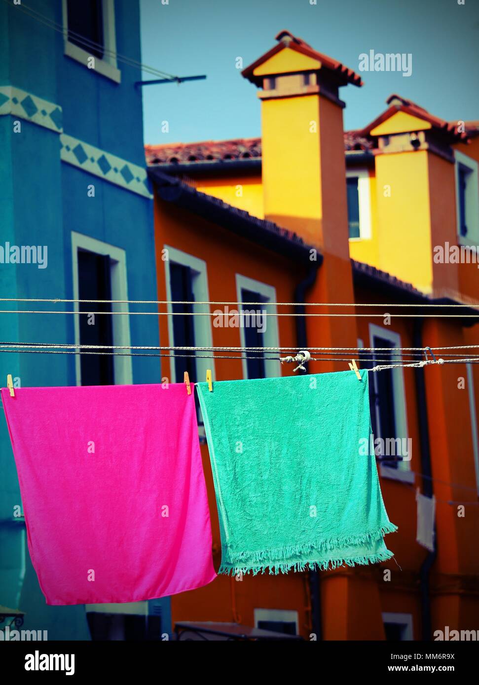 Burano is a small island near Venice in northern Italy famous  for its colorful houses and cloths in the courtyards of the houses Stock Photo