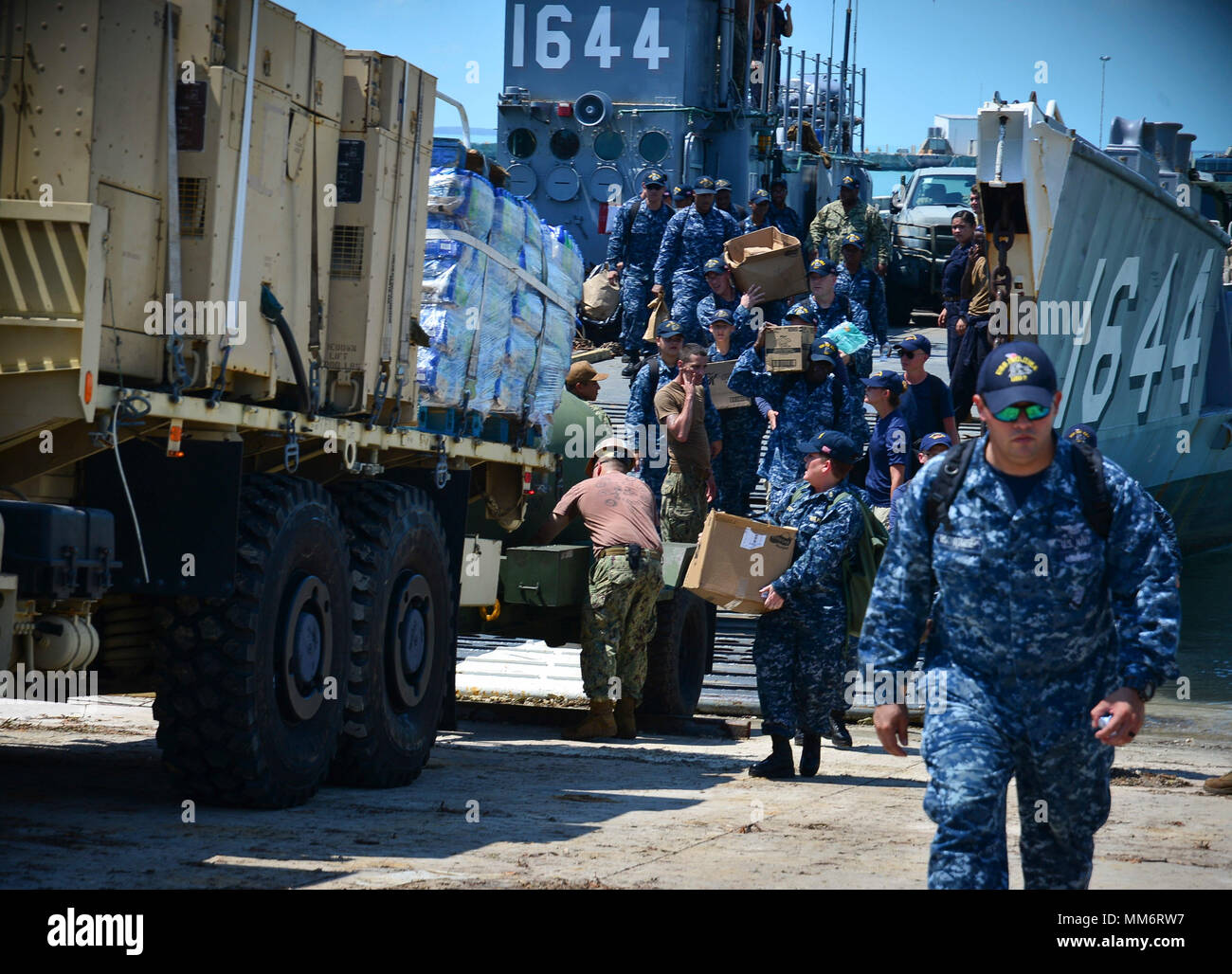 KEY WEST, Fla. (Sept. 13, 2017) Sailors attached to the amphibious assault ship USS Iwo Jima (LHD 7) exit Landing Craft Unit 1644, attached to Assault Craft Unit (ACU) 2, with supplies to assist with humanitarian relief efforts following Hurricane Irma's landfall in Key West, Florida.  The Department of Defense is supporting Federal Emergency Management Agency, the lead federal agency, in helping those affected by Hurricane Irma to minimize suffering and as one component of the overall whole-of-government response effort. (U.S. Navy photo by Mass Communication Specialist 3rd Class Daniel C. Co Stock Photo