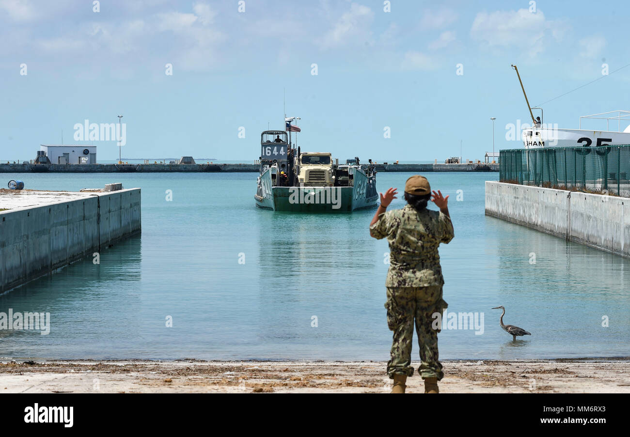 KEY WEST, Fla. (Sept. 13, 2017) Boatswain’s Mate Seaman Penelope Gutierrez-Betancourt, of San Clemente, California, directs Landing Craft Unit 1644, attached to Assault Craft Unit (ACU) 2, which is loaded with Sailors from the amphibious assault ship USS Iwo Jima (LHD 7) and supplies slated for use in humanitarian assistance efforts following Hurricane Irma’s landfall in Key West, Florida. The Department of Defense is supporting Federal Emergency Management Agency, the lead agency, in helping those affixed by Hurricane Irma to minimize suffering and as one component of the overall whole-of-gov Stock Photo