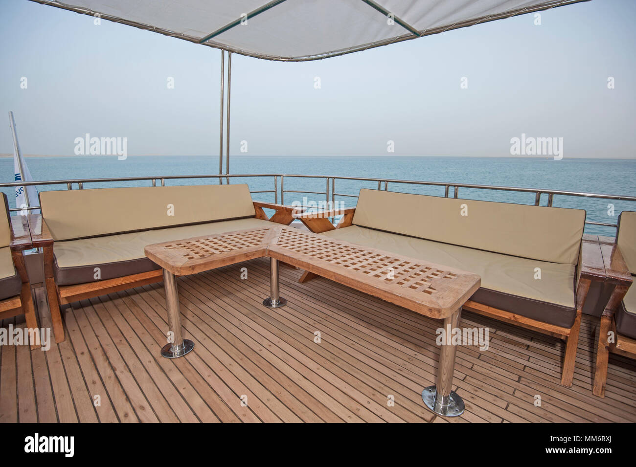 Rear teak deck of a large luxury motor yacht with chairs sofa table and