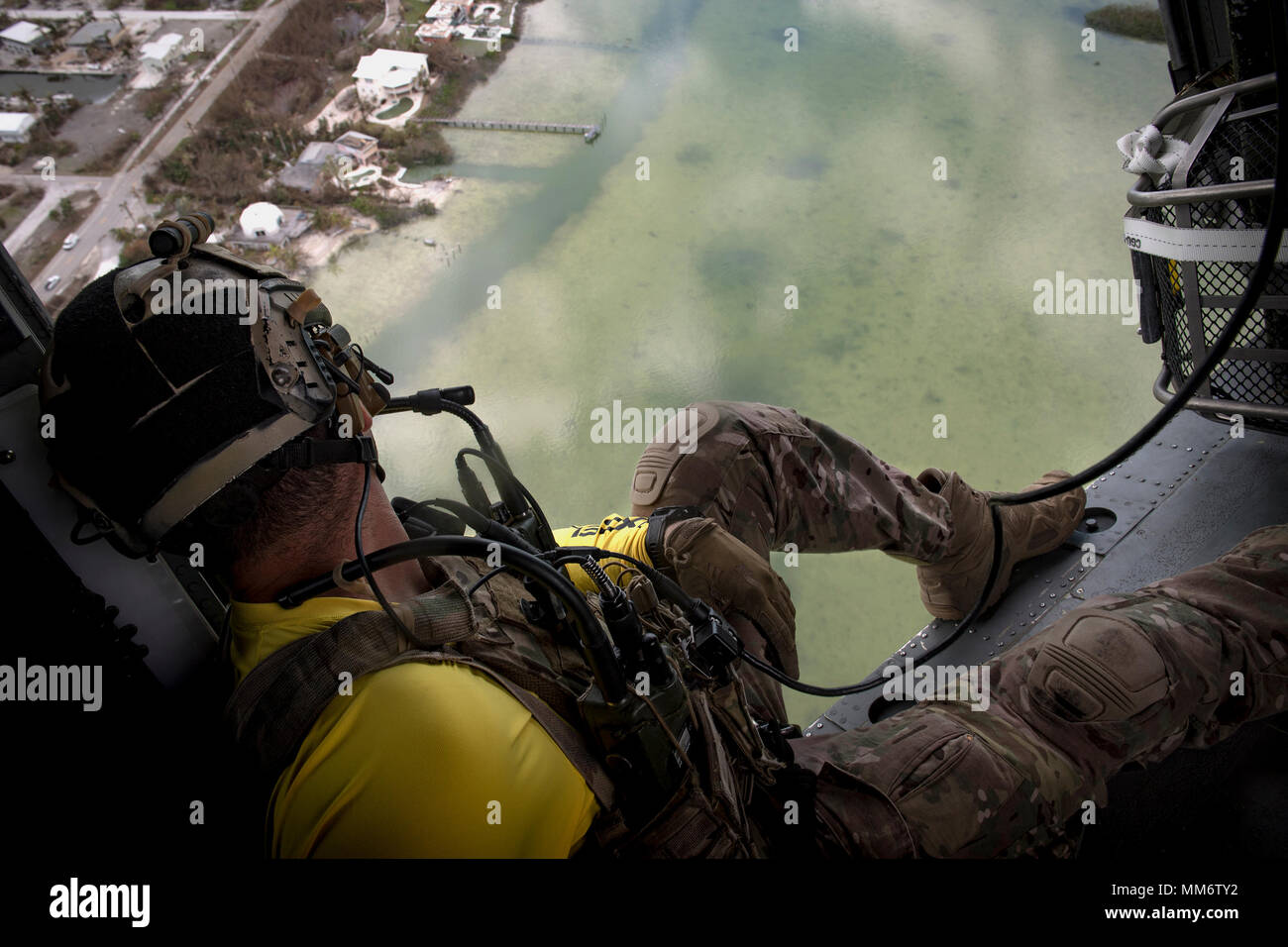 A pararescueman from the 48th Rescue Squadron scans the ground from an ...