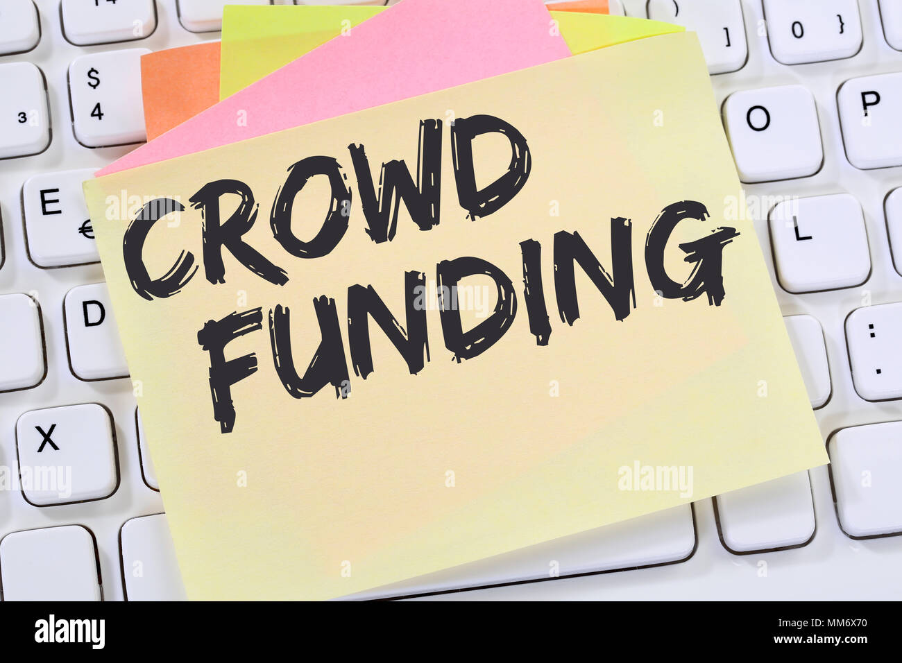 Crowd funding crowdfunding collecting money online investment internet business concept note paper desk computer keyboard Stock Photo