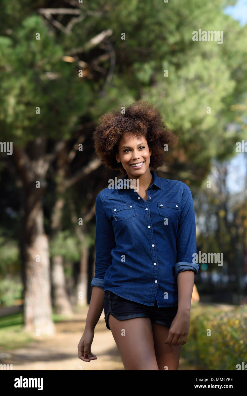 Smiling young dark-haired girl dressed in a black top, shorts