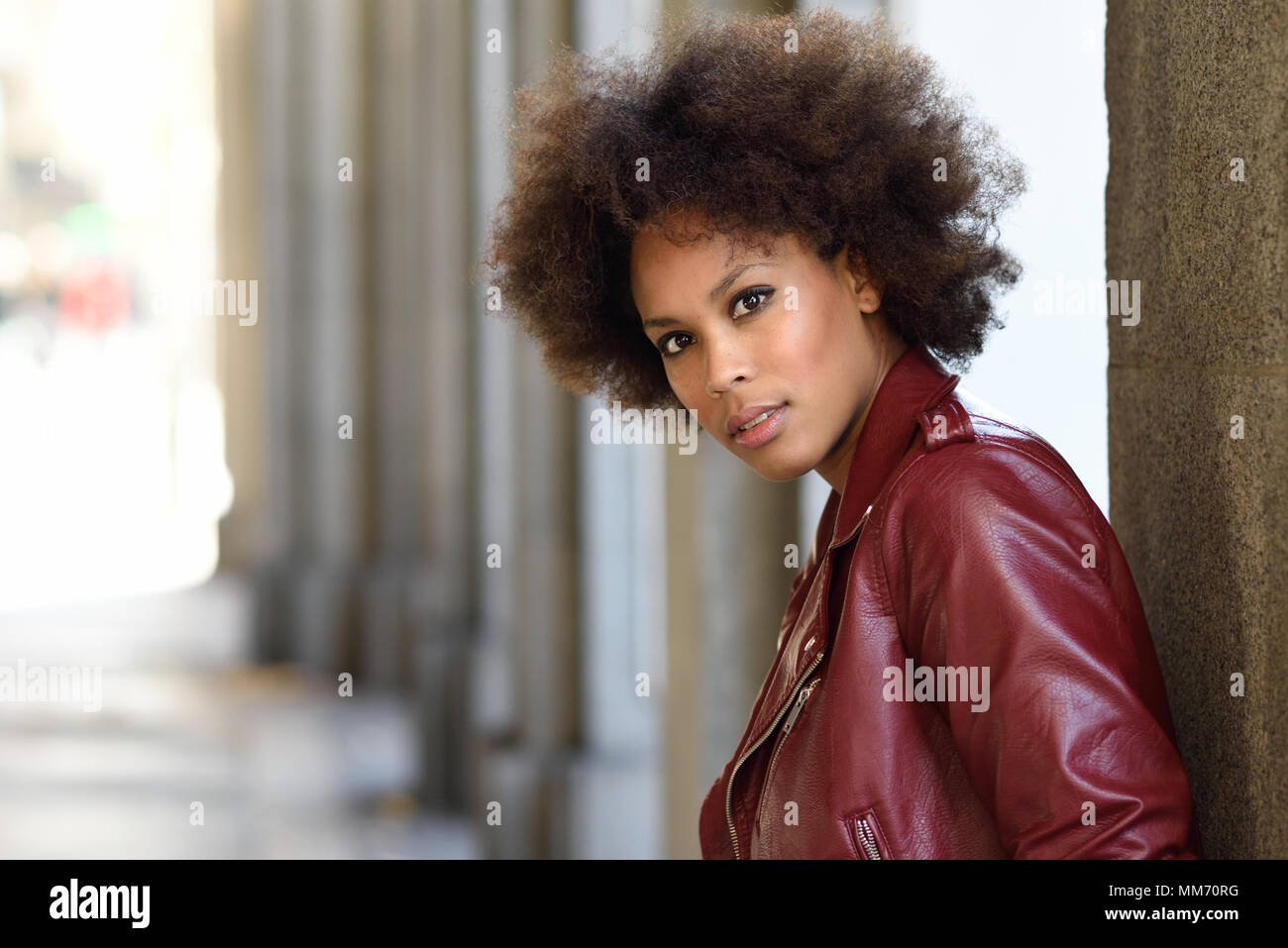 Young Black Female With Afro Hairstyle Standing In An Urban Street