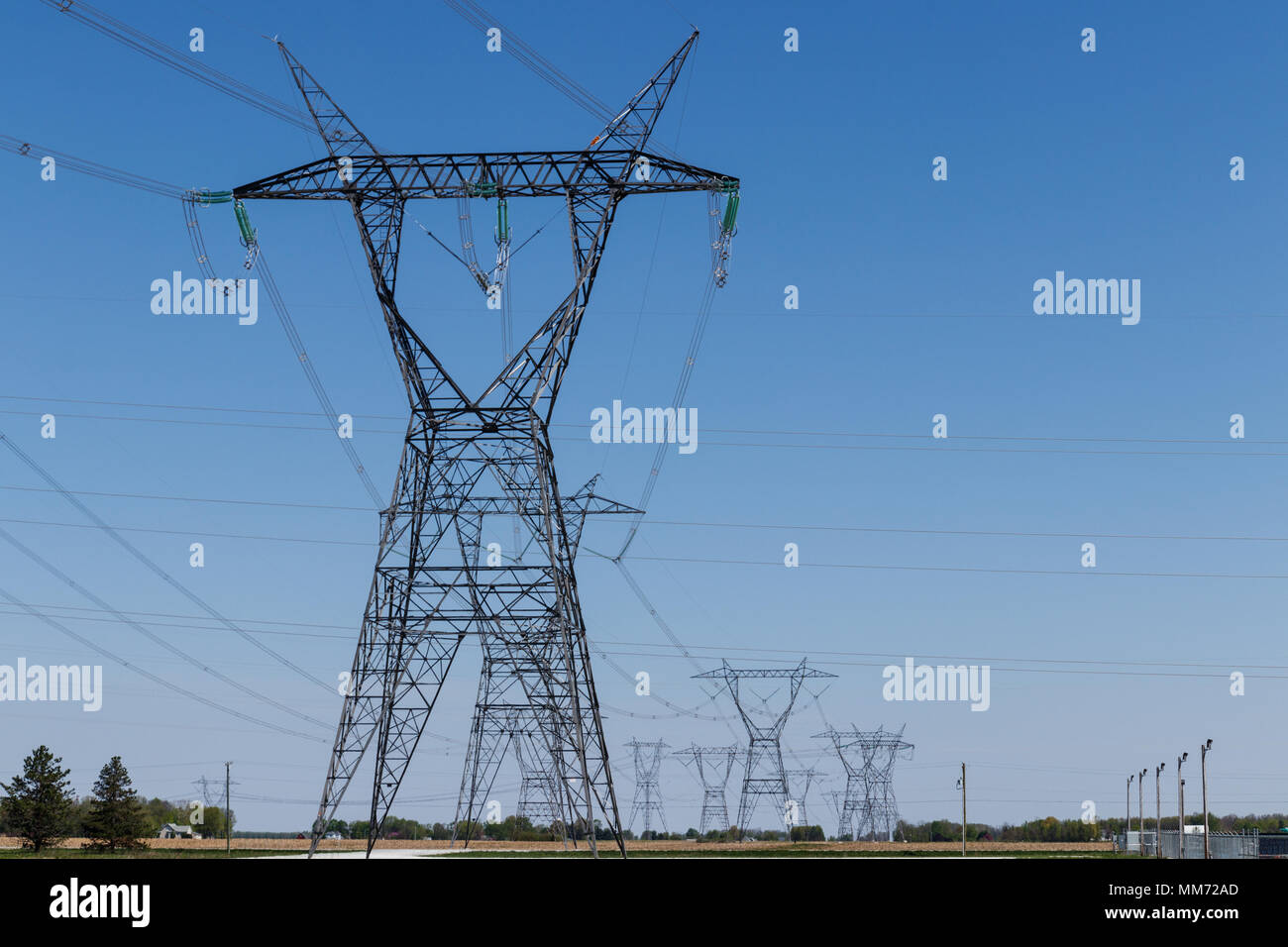 High-voltage power lines and pylon against blue sky I Stock Photo - Alamy