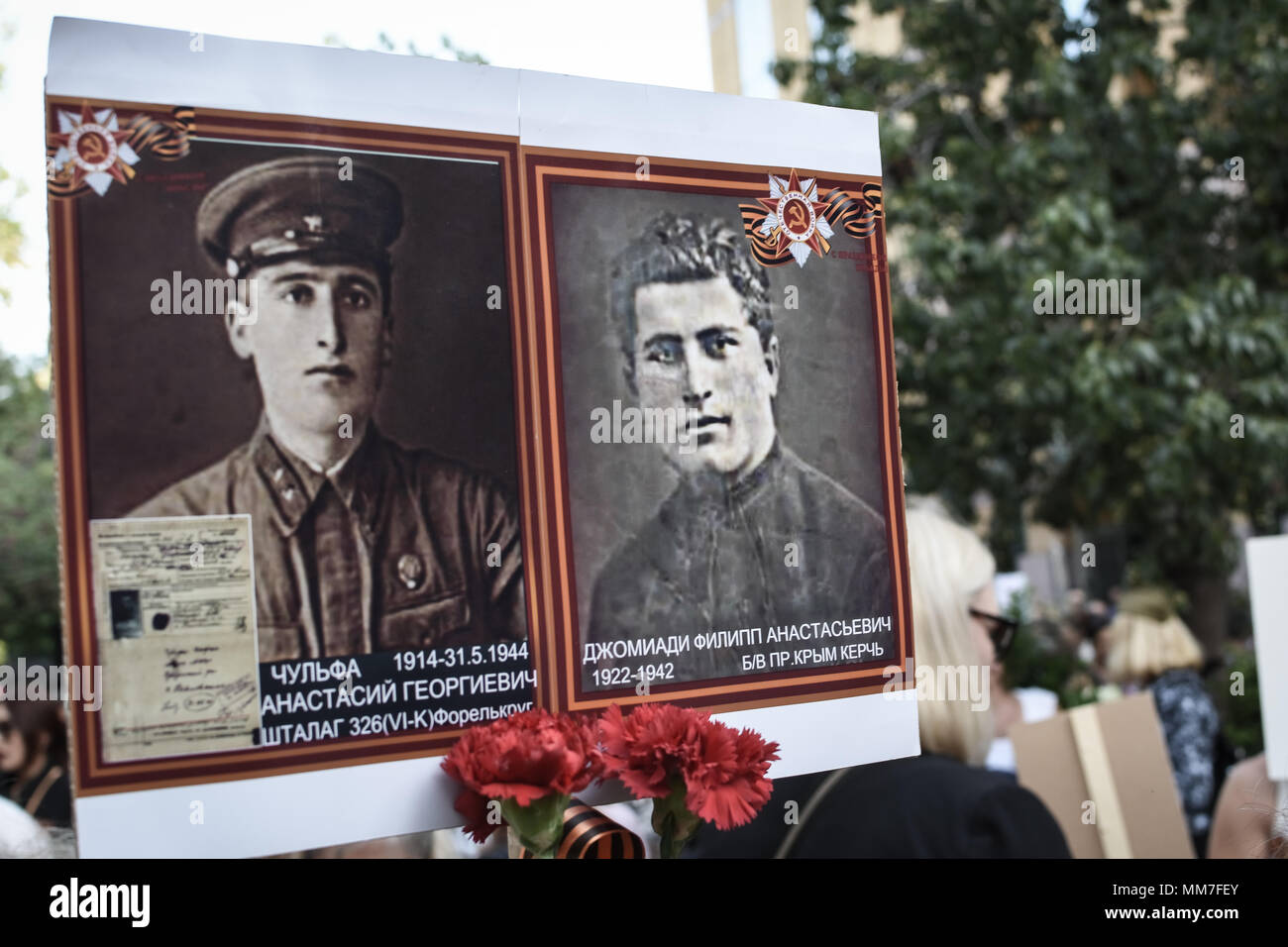 A placard with two old photographs seen at The Immortal Regiment march. Thousands of Russian citizens participated in the celebrations for the 73rd anniversary of the victory against fascism, which has been established as a Victory Day. With the military parade as well as the demonstration, the festive event took place across Russia, with citizens holding photos of their relatives who have either fought or been killed during the World War. Stock Photo