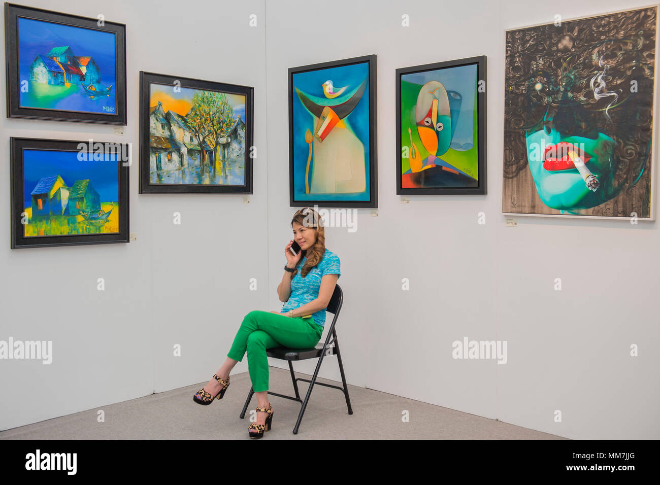 Hampstead, London, UK. 9th May, 2018. Angie with works on her Hanoi Art House stand - The Affordable Art Fair opens in Hampstead and runs until 14 May. The fair offers visitors a chance to purchase work from over 110 galleries at prices between £100 and £6,000 Credit: Guy Bell/Alamy Live News Stock Photo