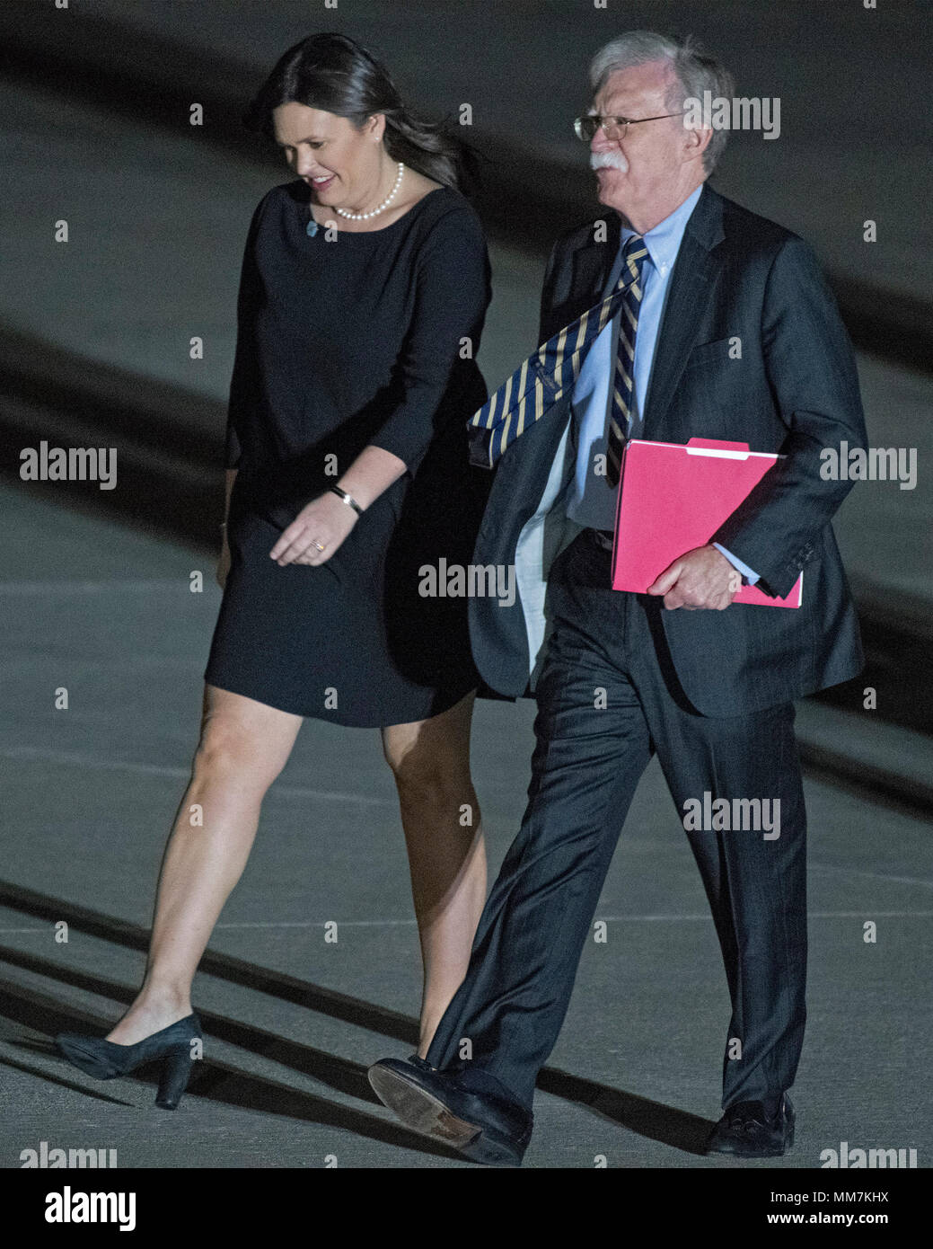 White House Press Secretary Sarah Sanders and National Security Advisor  John Bolton walk across the tarmac after accompanying United States  President Donald J. Trump to Joint Base Andrews in Maryland where he