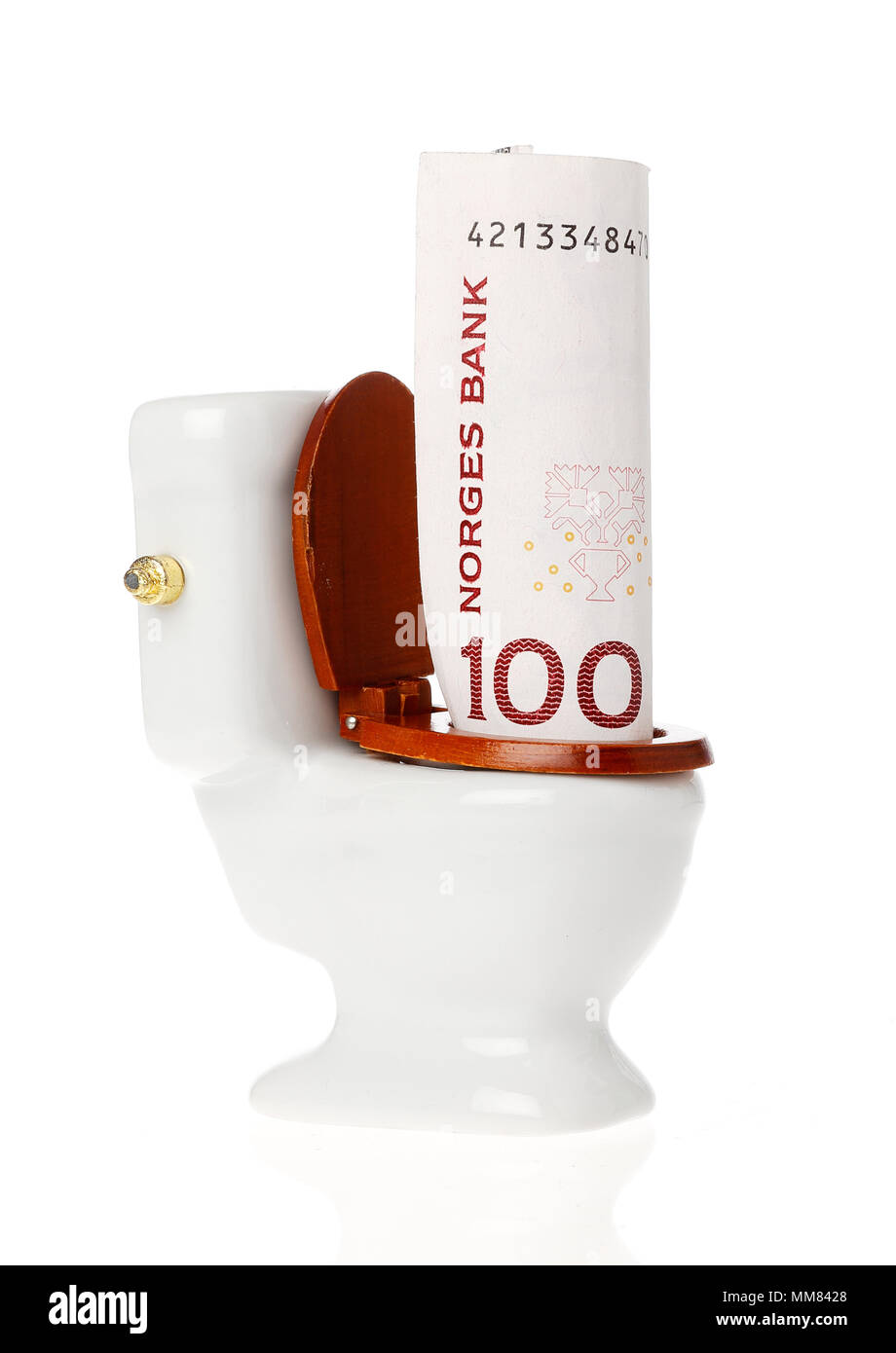 A one hundred kroner Norwegian banknote in the toilet isolated on whitebackground. Stock Photo