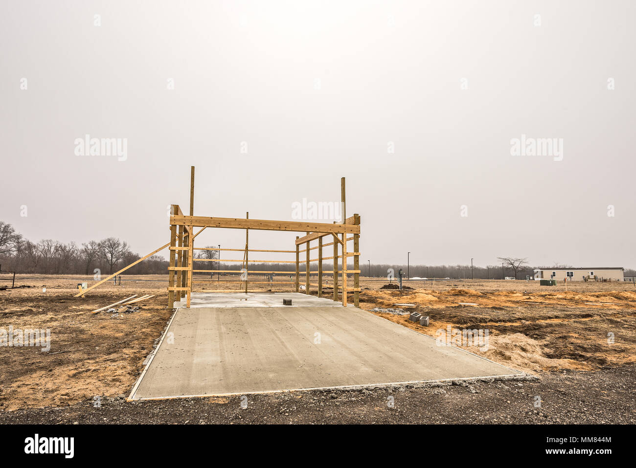 Concrete driveway poured in front of framed garage in a new development Stock Photo