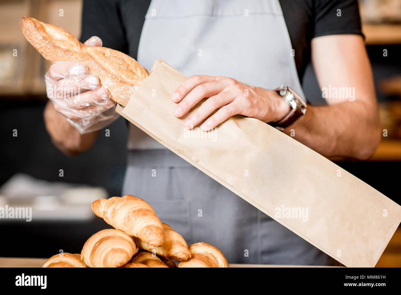 Packing bread into the paper bag Stock Photo
