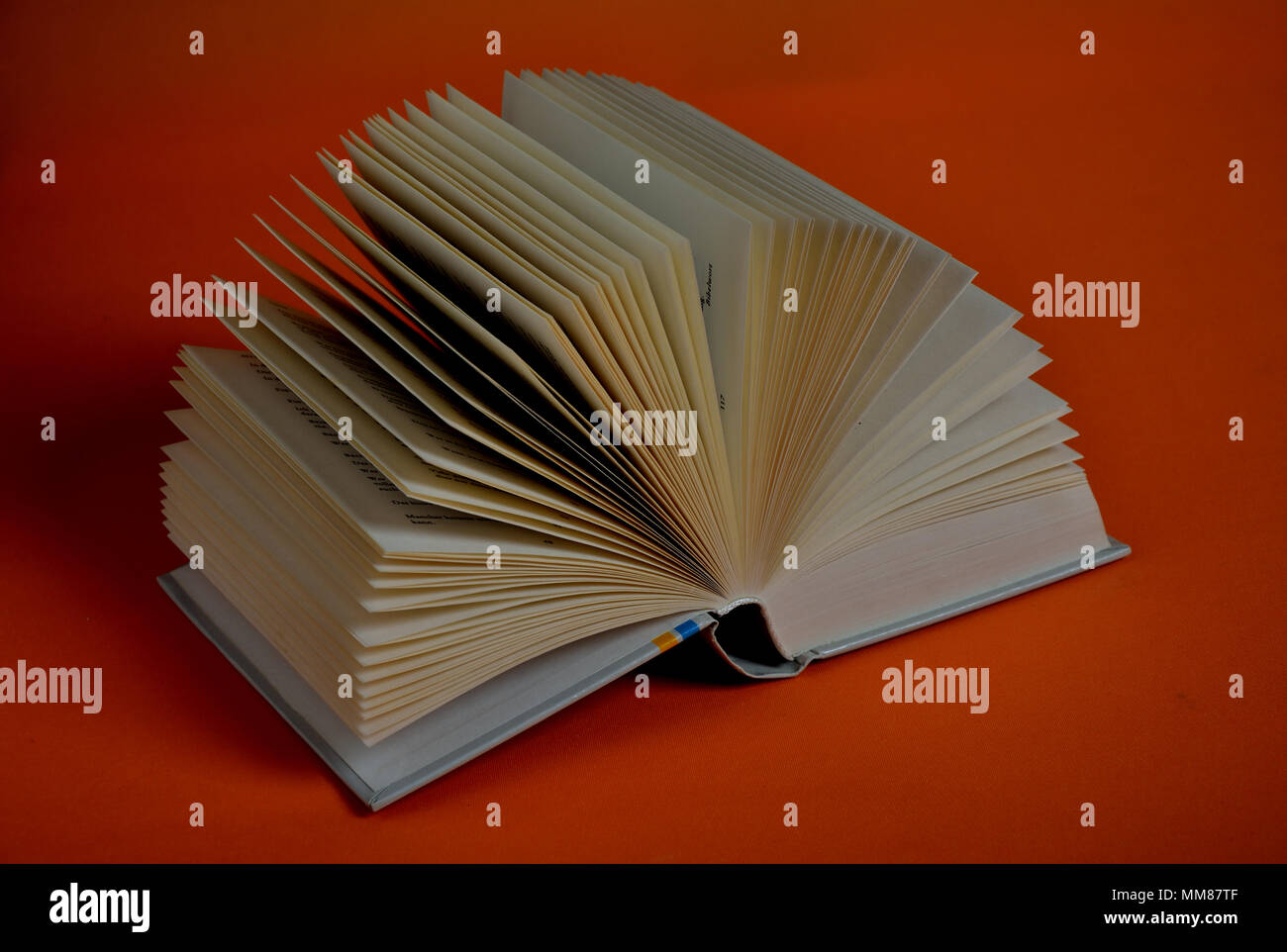 Fanned out book on orange background Stock Photo