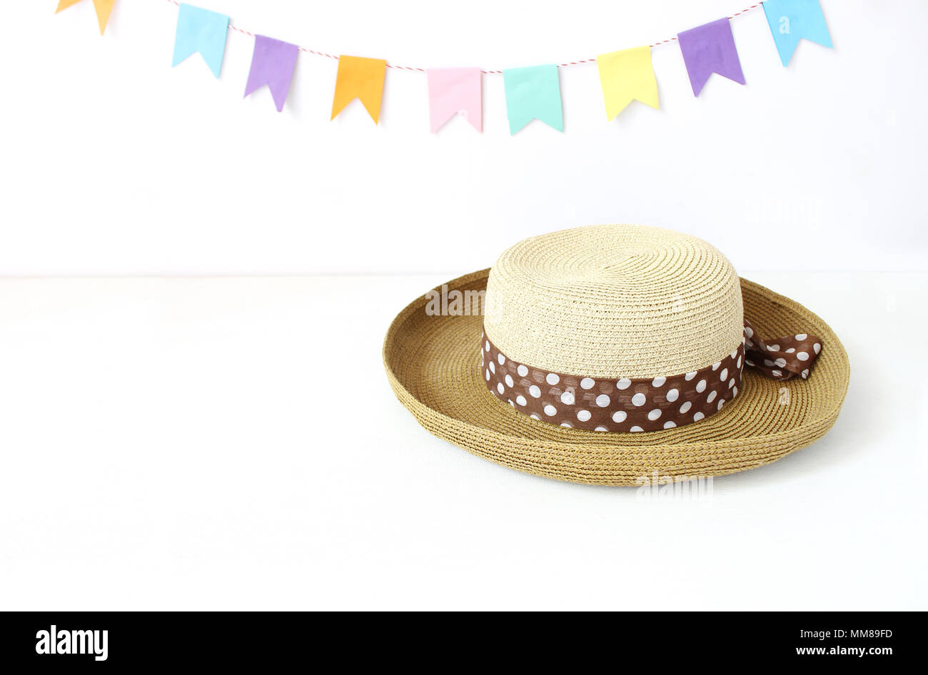 Straw Hat On White Table With Colorful Party Flags Bunting