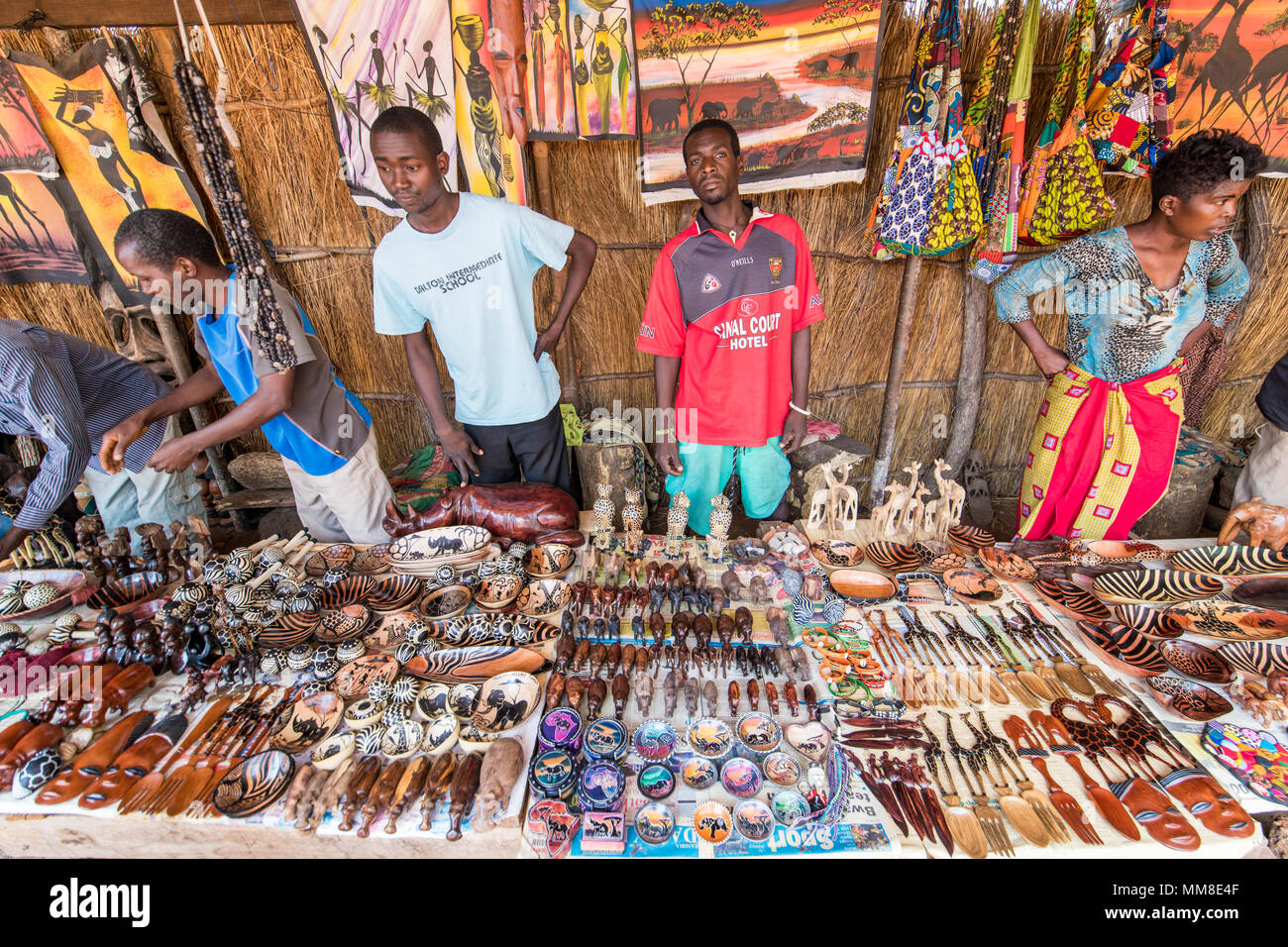 Group of Zambian vendors stand behind table full of handcrafted