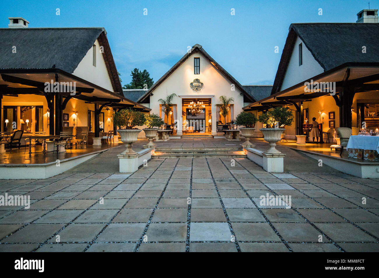 The lit up front entrance of the Royal Livingstone Hotel at dusk Livingstone, Zambia Stock Photo