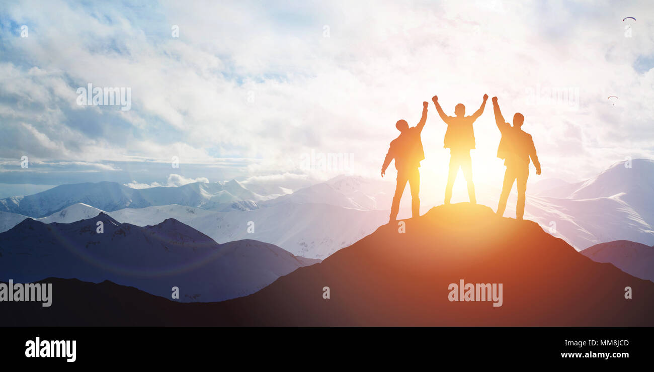Silhouette of the team on the peak of mountain Stock Photo
