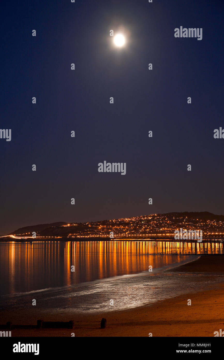 Full moon reflecting in the sea over Colwyn Bay beach at night, North Wales coast Stock Photo