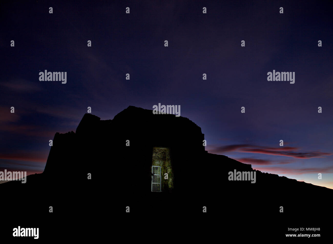 Jubilee Tower in silhouette at dawn on the summit of Moel Famau in the Clwydian Range AONB, North Wales Stock Photo