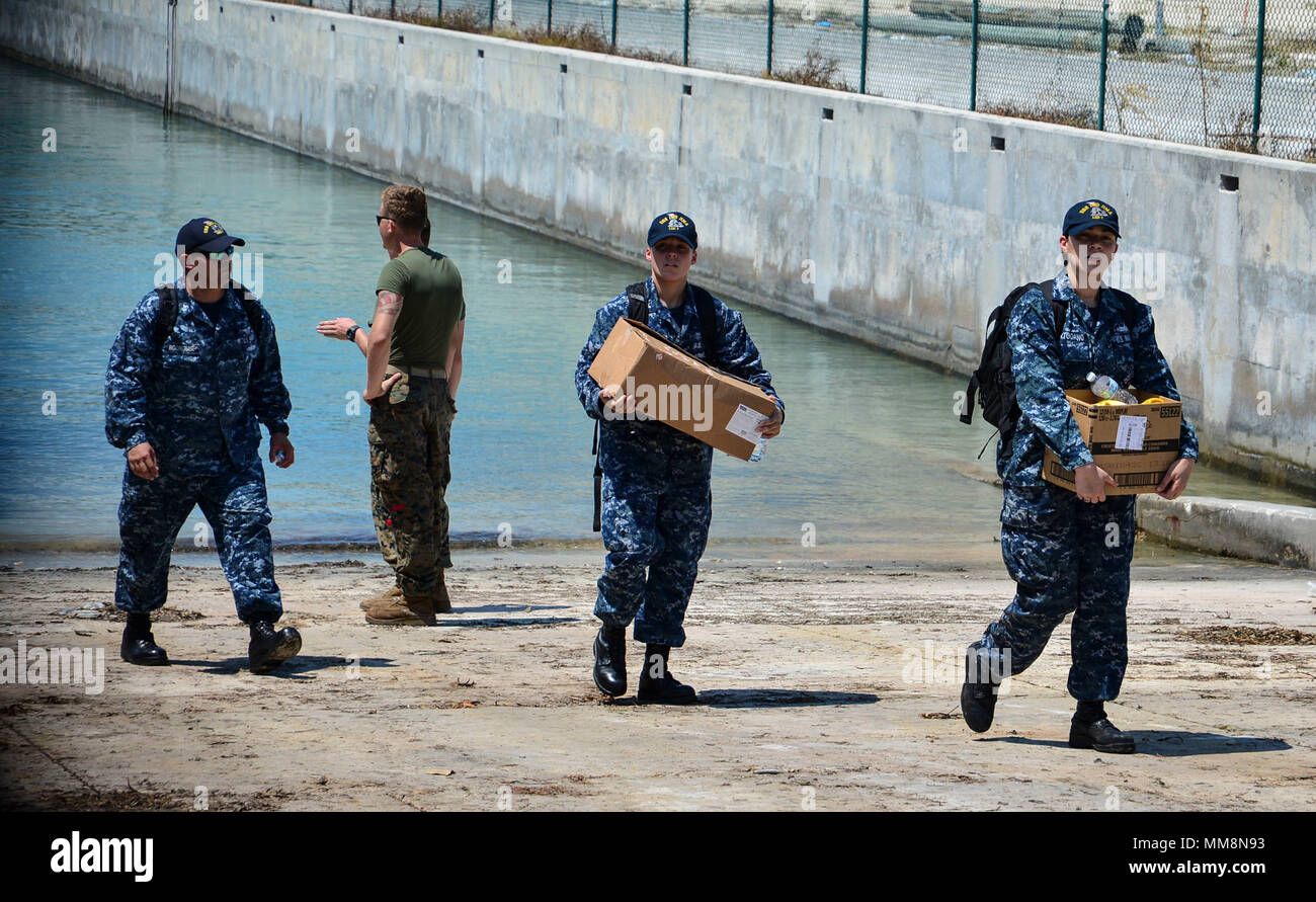 170913-N-AH771-0219 KEY WEST, Fla. (Sept. 13, 2017) Sailors attached to the amphibious assault ship USS Iwo Jima (LHD 7) exit Landing Craft Unit 1644, attached to Assault Craft Unit (ACU) 2, with supplies to assist with humanitarian relief efforts following Hurricane Irma's landfall in Key West, Fla. The Department of Defense is supporting the Federal Emergency Management Agency, the lead federal agency, in helping those affected by Hurricane Irma to minimize suffering and as one component of the overall whole-of-government response effort. (U.S. Navy photo by Mass Communication Specialist 3rd Stock Photo