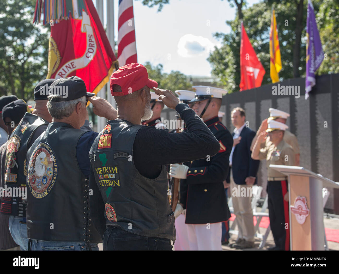 The U.S. Marine Corps Color Guard presents the National Ensign and the U.S. Marine Corps Battle Colors during a Vietnam War pinning ceremony as a part of Marine Week, Detroit, MI., Sept. 8, 2017. The Traveling Vietnam Memorial Wall was set up alongside the Detroit Riverwalk where ten Vietnam veterans received commemorative pins to honor their service and sacrifice to our country. (Official U.S. Marine Corps photo by Cpl. Robert Knapp/Released) Stock Photo