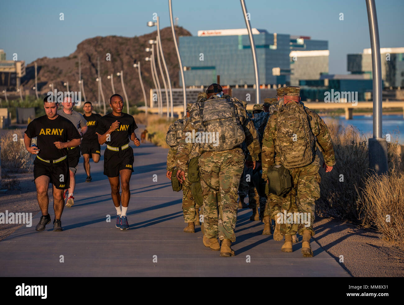 A group of U.S. Army Reserve Soldiers from the 387th Military Police Battalion run past a group of command sergeants major from across the 200th Military Police Command participating in a team-building ruck march during a 'CSM Huddle' in Scottsdale, Arizona, Sept. 16, 2017. During the huddle, the command sergeants major discussed critical topics relevant to their command and their units in order to increase readiness to deploy. (U.S. Army Reserve photo by Master Sgt. Michel Sauret) Stock Photo