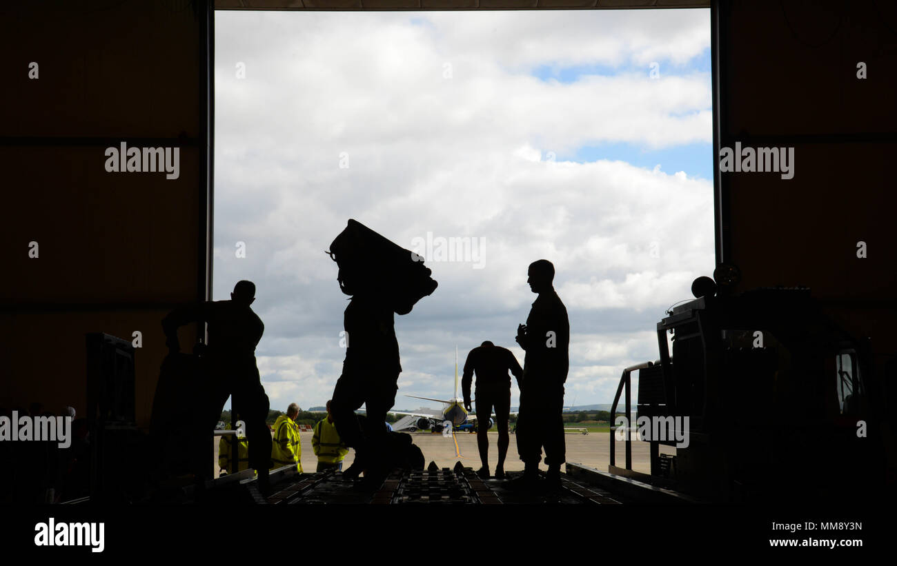 Airmen and volunteers help unload luggage from a truck after their arrival to Fairford Royal Air Force Base, Sept. 11, 2017. U.S. Strategic Command bomber forces regularly conduct combined theater security cooperation engagements with allies and partners, demonstrating the U.S. capability to command, control and conduct bomber missions across the globe. Bomber missions demonstrate the credibility and flexibility of the military's forces to address today's complex, dynamic and volatile global secruty environment. (U.S. Air Force photo/Staff Sgt. Benjamin Raughton) Stock Photo