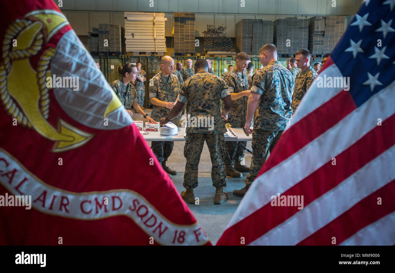 U.S. Marines with Marine Tactical Air Command Squadron 18 pass out cake to fellow Marines during the 50th anniversary celebration of MTACS-18 at Marine Corps Air Station Futenma, September 15, 2017. During the ceremony, Marines read excerpts about the courageous efforts put forth by MTACS-18. The squadron was activated on September 1, 1967 at Da Nang, Republic of Vietnam, as Headquarters and Headquarters Squadron 18, Marine Air Control Group 18, 1st Marine Aircraft Wing. (U.S. Marine Corps photo by Lance Cpl. Andy Martinez) Stock Photo