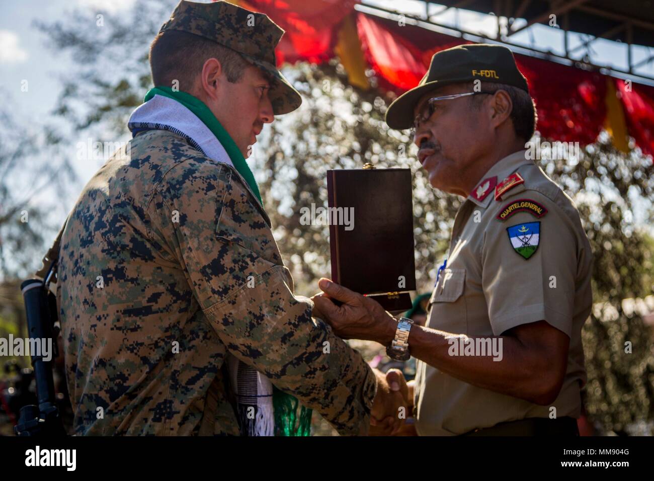 U.S. Marine Corps Capt. Andrew Buck, left, platoon commander for Task Force Koa Moana 17 receives a plaque during a closing ceremony for Exercise Crocodilo in Metinaro, Timor Leste, Sept. 14, 2017. Koa Moana 17 is designed to improve interoperability with our partners, enhance military-to-military relations, and expose the Marine Corps forces to different types of terrain for familiarity in the event of a natural disaster in the region.  (U.S. Marine Corps photo by MCIPAC Combat Camera Lance Cpl. Juan C. Bustos) Stock Photo