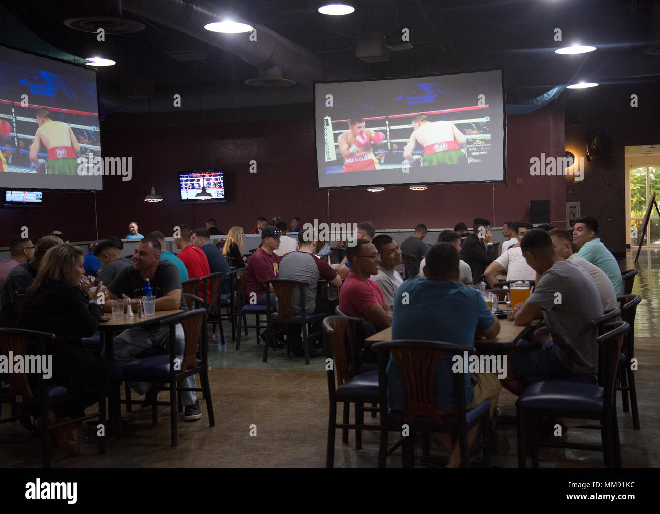 U.S. Marines and Sailors stationed at Marine Corps Air Station Yuma, Ariz., gather at the Sonoran Pueblo on Sept. 16, 2017, to watch the Canelo Alvarez and Gennady Golovkin boxing match. Marine Corps Community Services planned the event for Marines, Sailors and their families to watch and enjoy together. (U.S. Marine Corps photo taken by Lance Cpl. Sabrina Candiaflores) Stock Photo