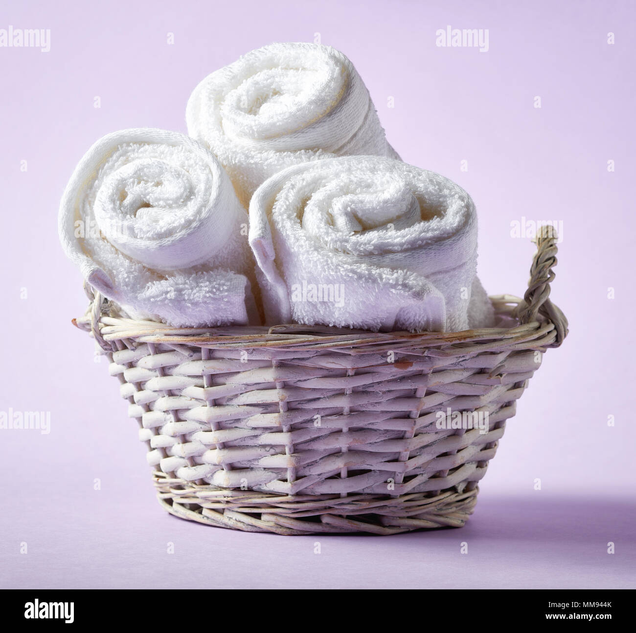 White Spa Towels In Wicker Basket On Light Purple Background Top View Stock Photo Alamy