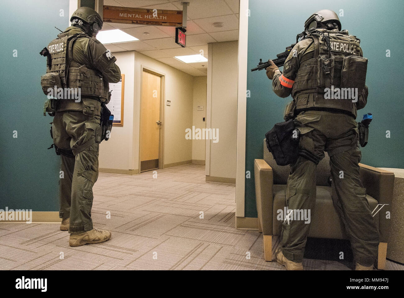 Two Delaware State Police Special Weapons and Tactics team members take  positions outside of the Mental Health clinic during an active shooter  exercise Sept. 12, 2017, at the Base Clinic, Dover Air