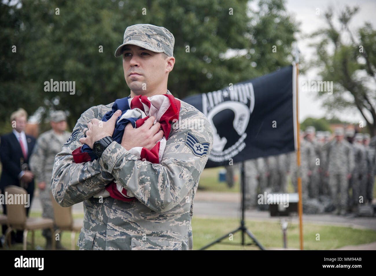A Vance Airman cradles the American Flag during a retreat ceremony on Sept. 15, 2017 at the Vance Air Force Base flagpole. The retreat ceremony was performed in honor of POW/MIA Day to remember our current and past POW/MIA’s. Stock Photo