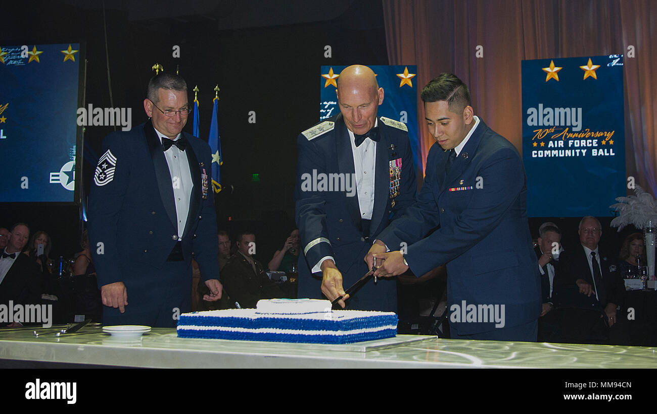Maj. Gen. Timothy Zadalis (center), U.S. Air Forces in Europe and Africa Ramstein Air Base, Germany vice commander, and Airman Basic Luis Vargas, a 71st Medical Operations Squadron aerospace and operational physiology technician, cut the ceremonial birthday cake Sept. 16, 2017, at the 70th Anniversary Air Force Community Ball in Enid, Oklahoma. It is tradition to have the oldest and the youngest active duty member in the room cut the cake together. (U.S. Air Force photo by Airman 1st Class Taylor Crul) Stock Photo