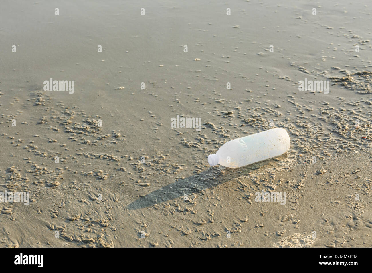 Discarded water bottle laying on a beach. Stock Photo