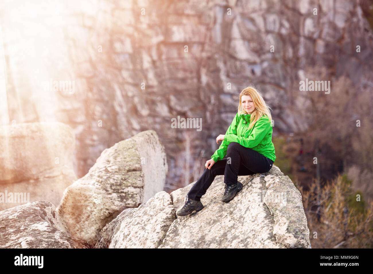 Young woman sitting on cliff's edge Stock Photo - Alamy