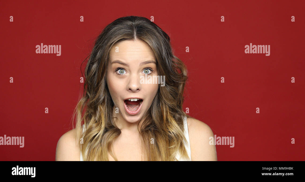 Female Face in Shock on red Close Up Stock Photo