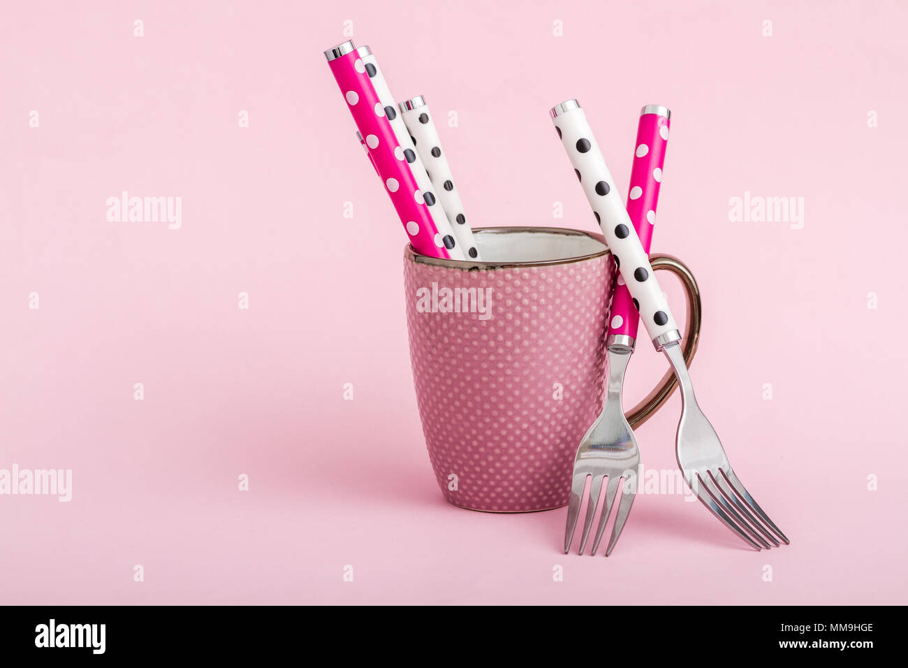 Colorful ceramic coffee mugs and forks on pink background Stock Photo ...