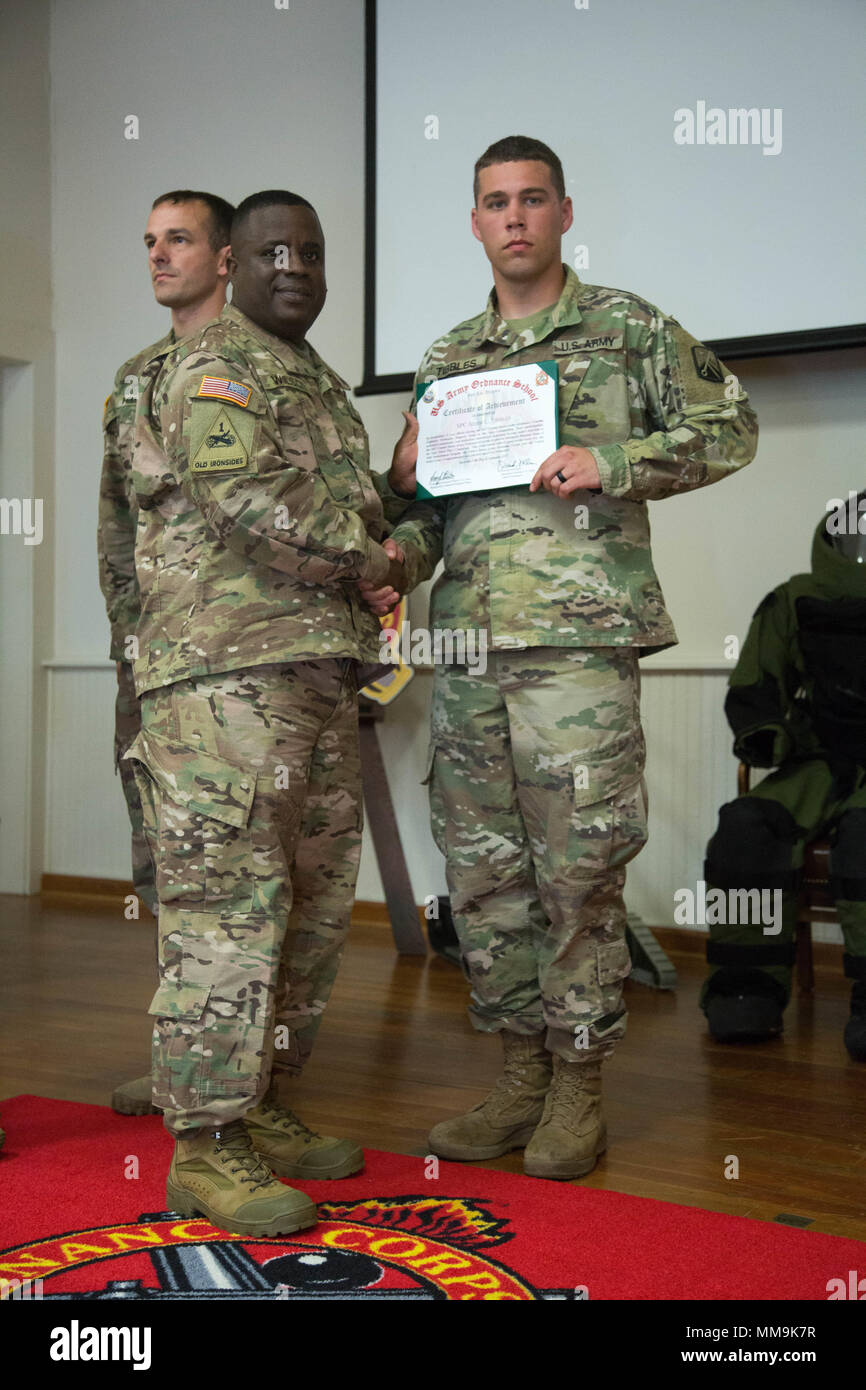 U.S. Army Brig. Gen. David Wilson, the 40th Chief of the Ordnance and Commandant of the United States Army Ordnance School, awards Spc. Adam Tibbles with the Certificate of Achievement during the closing ceremony for the Explosive Ordnance Disposal (EOD) Team of the Year at Fort A.P. Hill, Va., Sept. 15, 2017. The U.S. Army Ordnance Crucible is a three-part competition, comprised of the Ammunition Transfer Holding Point, Combat Repair Team, and now on their final course the Explosive Ordnance Disposal, which is designed to get Soldiers' teamwork and critical thinking skills.  (U.S. Army photo  Stock Photo