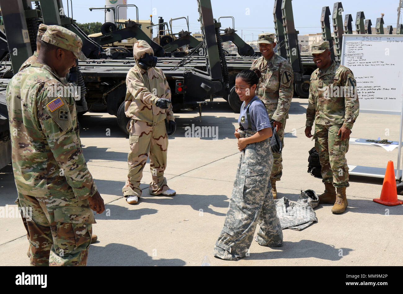 Army recruits try on different types of military gear as soldiers look
