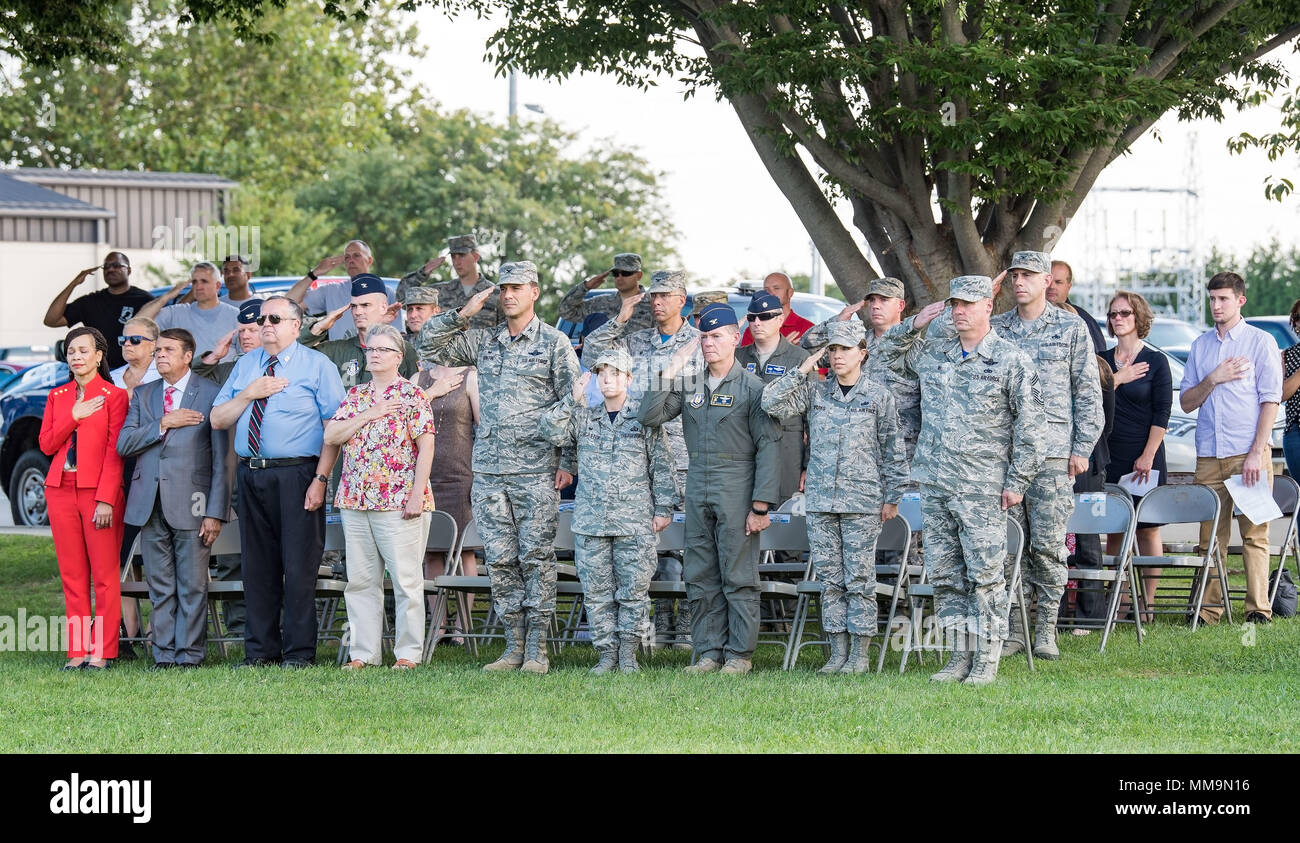 Team Dover members and guests render a salute or place their hand over their heart while the base honor guard lowers the U.S. flag during the National Prisoner of War and Missing in Action Recognition Day ceremony Sept. 15, 2017, on Dover Air Force Base, Del. One hundred seventy-eight fallen service members from previous wars and conflicts were repatriated this past year. (U.S. Air Force photo by Roland Balik) Stock Photo