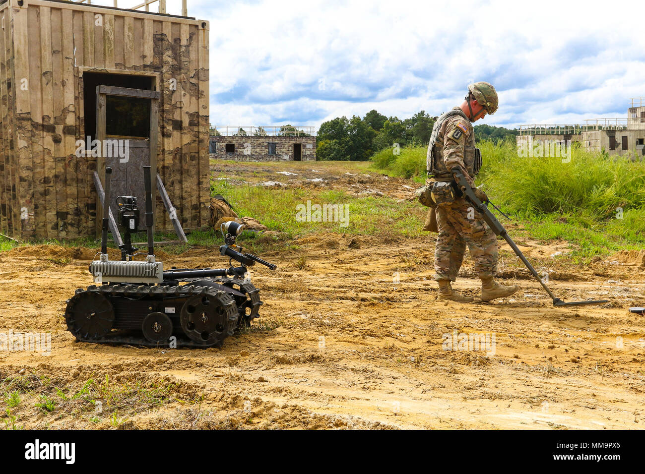 Sgt. 1st Class Joshua Tygret, assigned to 744th Ordnance Disposal Company,  52nd Explosive Ordnance Group, uses a metal detector to safely approach the  mission objective during the protection works lane of the