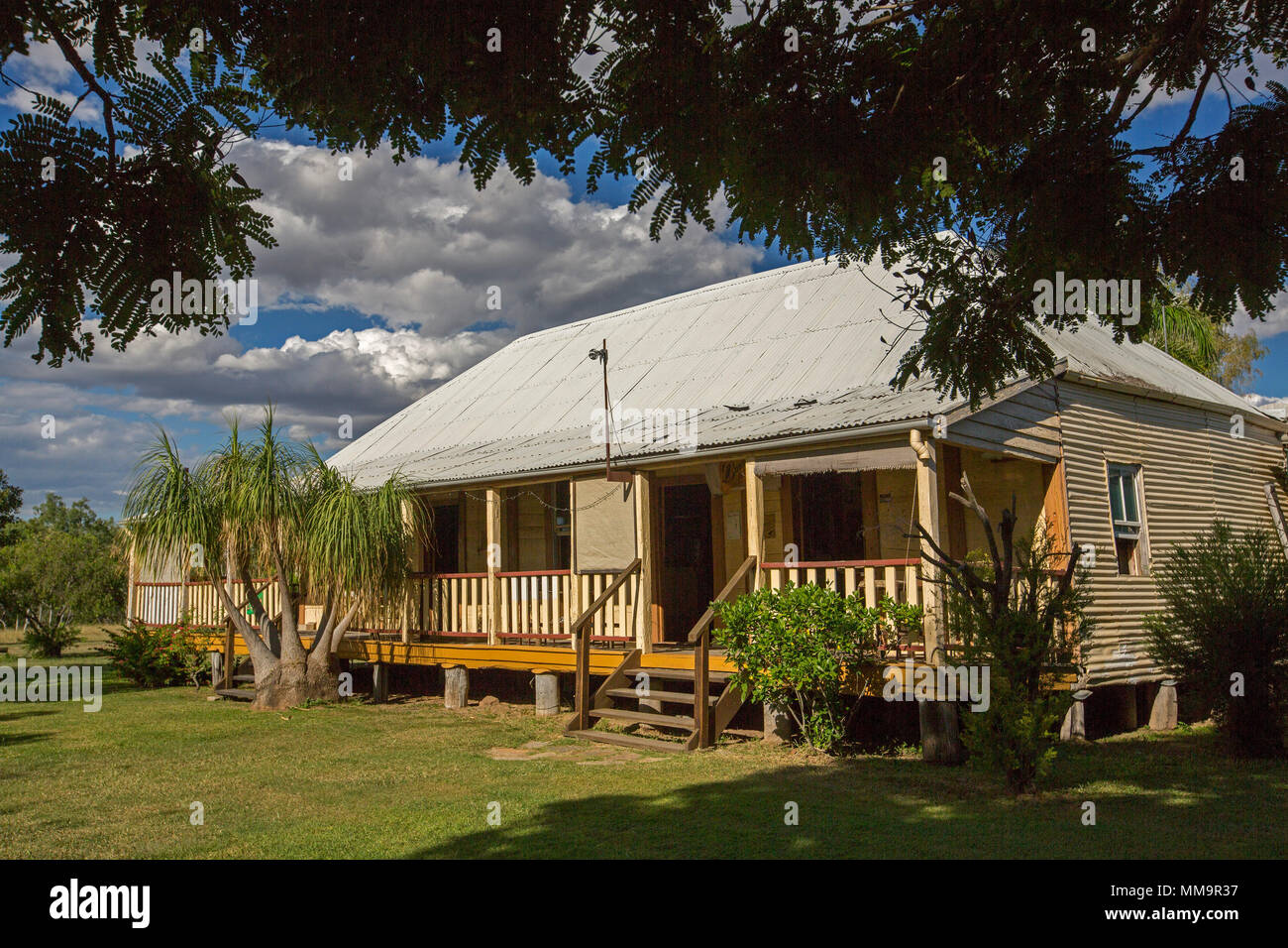 Heritage listed 1860s Bowen River Hotel, classic style timber building among gardens and trees under blue sky in western Queensland Australia Stock Photo