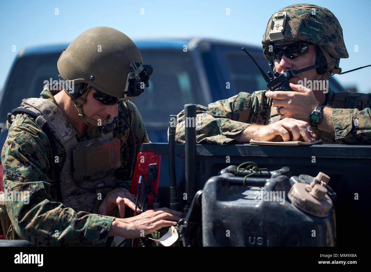 U.S Marine Corps Maj. Josh Foster, Air Ordnance Disposal Instructor, left, and Capt. David Hirt, AH-1 Instructor with Marine Aviation Weapons and Tactics Squadron One (MAWTS-1) provide digitally aided close air support using radios and tablets in support of Weapons Tactics Instructors course (WTI) 1-18 at Fire Base Burt, Calif., Sept. 22, 2017. WTI is a seven-week training even hosted by MAWTS-1 cadre, which emphasizes operational integration of the six functions of Marine Corps aviation in support of a Marine Air Ground Task Force and provides standardized advance tactical training and certif Stock Photo