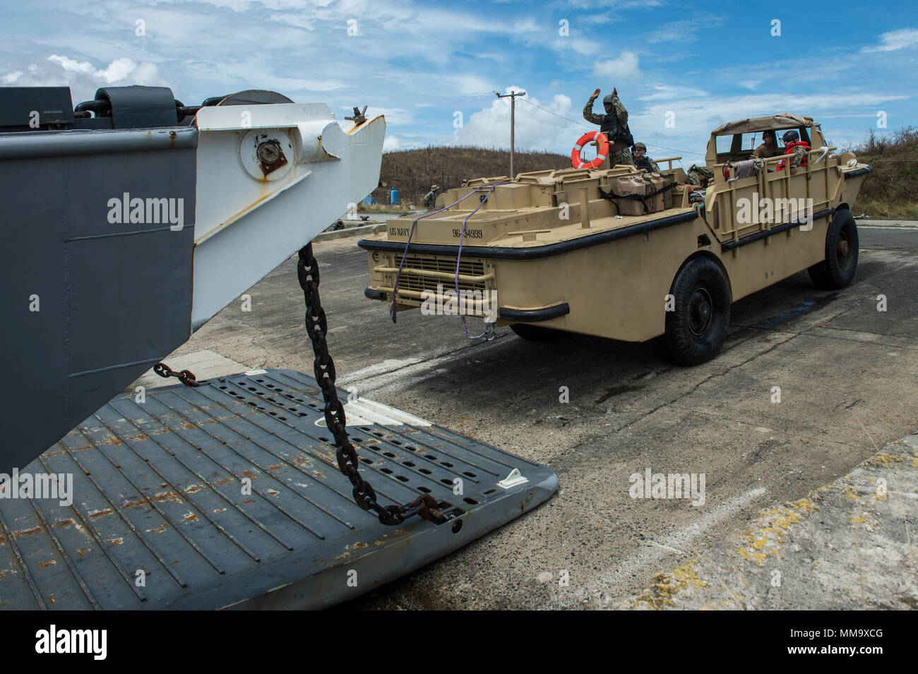 170925-N-WB378-0132 PUERTO RICO, (Sept. 25, 2017) –Boatswain’s Mate 3rd Class Ibrahima Thiaw, assigned to Beach Master Unit Two, guides a lighter amphibious resupply and cargo vehicle onto a landing craft utility in Puerto Rico, Sept. 25, 2017. The Department of Defense is supporting Federal Emergency Management Agency (FEMA), the lead federal agency, in helping those affected by Hurricane Maria to minimize suffering and is one component of the overall whole-of-government response effort. (U.S. Navy photo by Mass Communication Specialist 1st Class Blake Midnight/RELEASED) Stock Photo