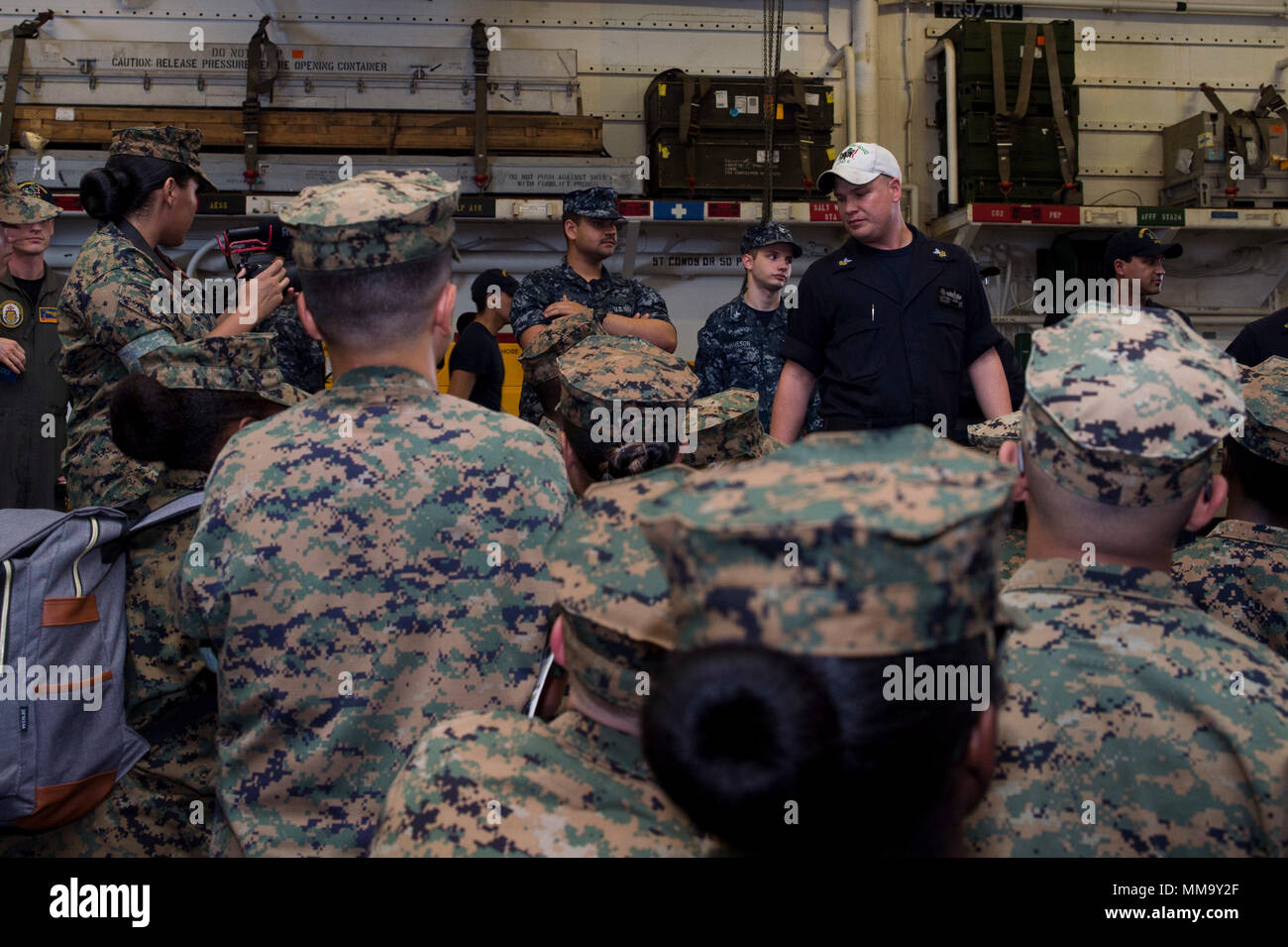 170921-N-RD713-044 WHITE BEACH, Okinawa (Sept. 21, 2017) Quartermaster 1st Class Matthew Lenerville, from Richardton, N.D., gives a safety brief to Marine Corps Junior ROTC students from Kubasaki High School during a tour of the amphibious assault ship USS Bonhomme Richard (LHD 6). Bonhomme Richard, flagship of the Bonhomme Richard Amphibious Ready Group, is operating in the Indo-Asia-Pacific region to enhance partnerships and be a ready-response force for any type of contingency. (U.S. Navy photo by Mass Communication Specialist 3rd Class Zachary DiPadova/Released) Stock Photo