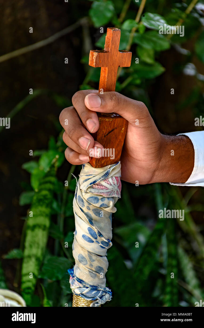 Hands holding stick with wooden crucifix in folklore and popular religious festival in Brazil Stock Photo