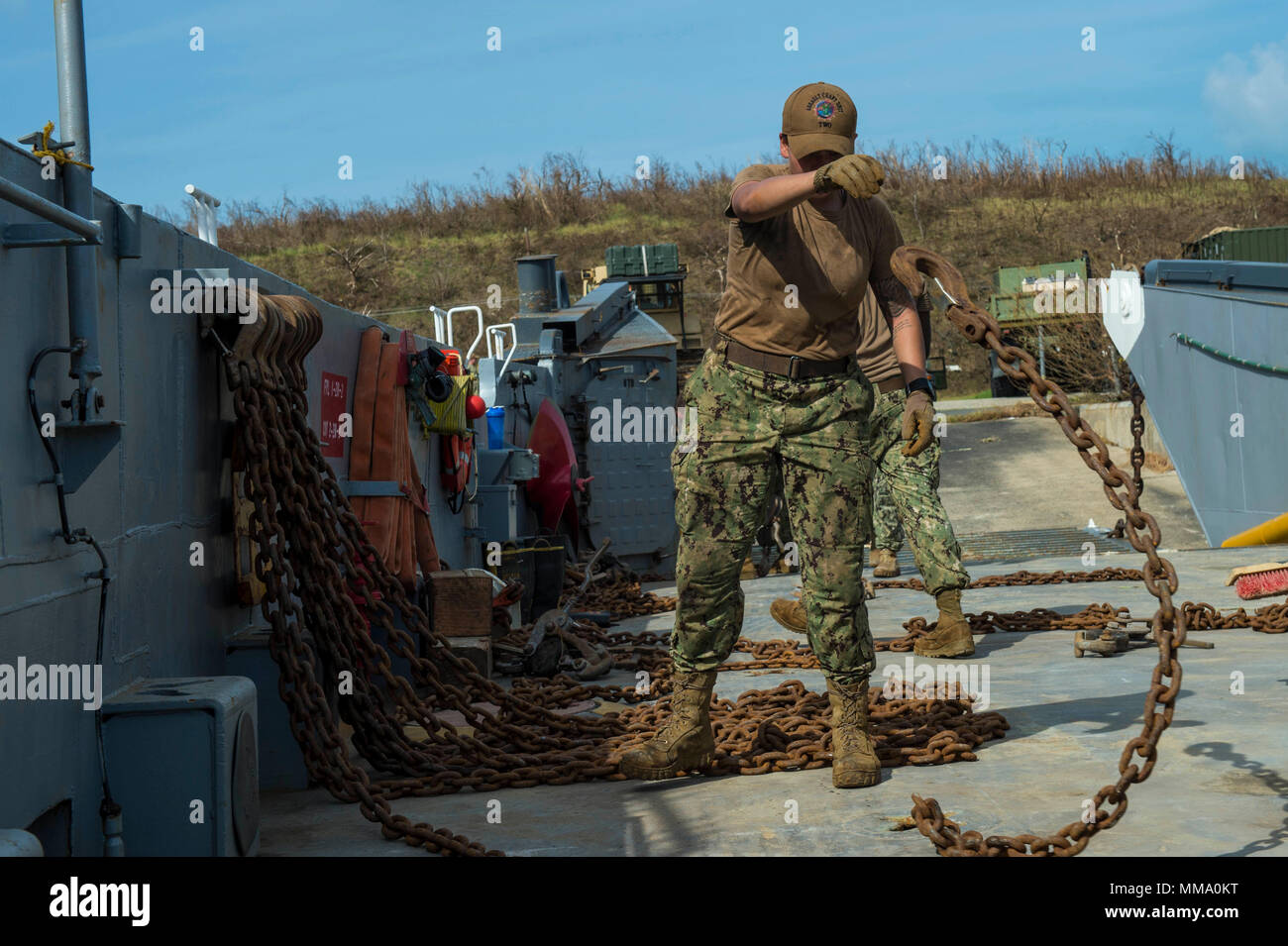 170924-N-WB378-0039 PUERTO RICO, (Sept. 24, 2017) – Boatswain’s Mate 2nd Class Sharon Estrada, assigned to Assault Craft Unit Two, moves chains on the deck of a landing craft utility after disembarking troops and cargo in Puerto Rico, Sept. 24, 2017. The Department of Defense is supporting Federal Emergency Management Agency (FEMA), the lead federal agency, in helping those affected by Hurricane Maria to minimize suffering and is one component of the overall whole-of-government response effort. (U.S. Navy photo by Mass Communication Specialist 1st Class Blake Midnight/RELEASED) Stock Photo