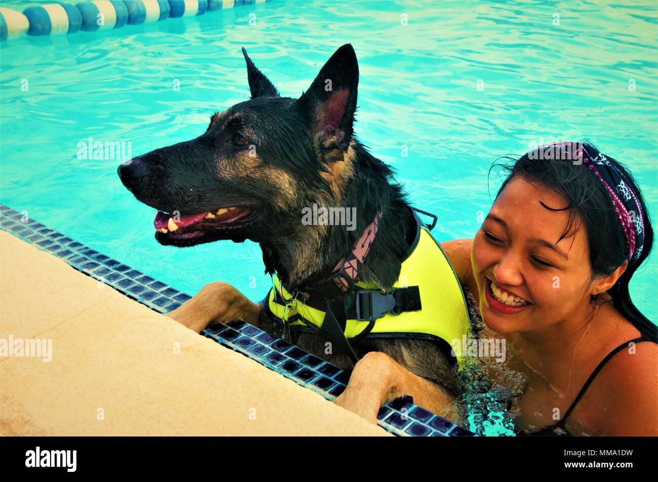 - Stephanie Flores cuddles up with her Labrador retriever mix during the third annual Doggy Swim Day September 23, 2017 at the Fort Bliss Community Pool. Flores looks forward to this event ever year. (Army photo by SGT Apryl N. Bowman, 24th Press Camp Headquarters) Stock Photo